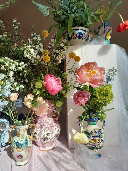 cinq vases comprenant des bouquets de fleurs de différentes couleurs, composés de roses, de jaune, de blanc et de feuilles vertes, ainsi que de fleurs jaunes et rouges