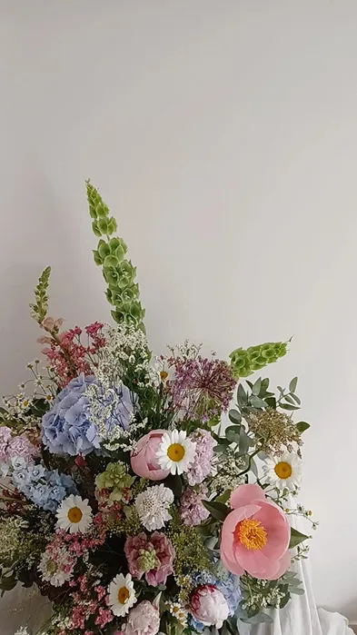 un gros bouquet de fleurs comprenant des couleurs rose, blanc, vert et violet