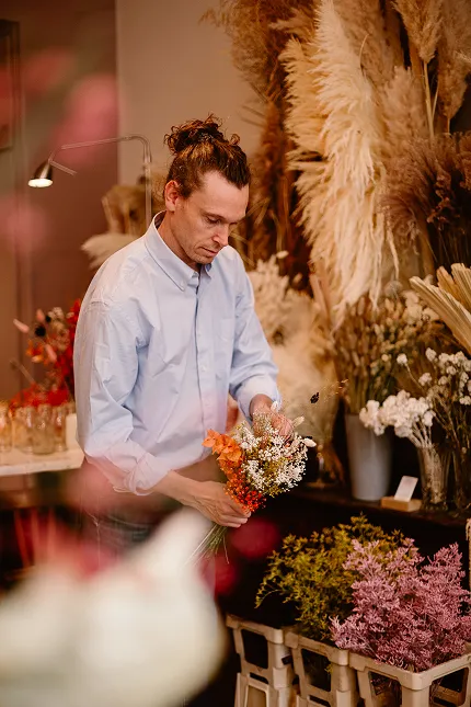 le fleuriste Stéphane en train de préparer un bouquet de fleurs dans sa boutique