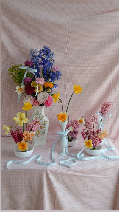 plusieurs petits vases avec des fleurs composées des couleurs jaune, rose, orange et violette