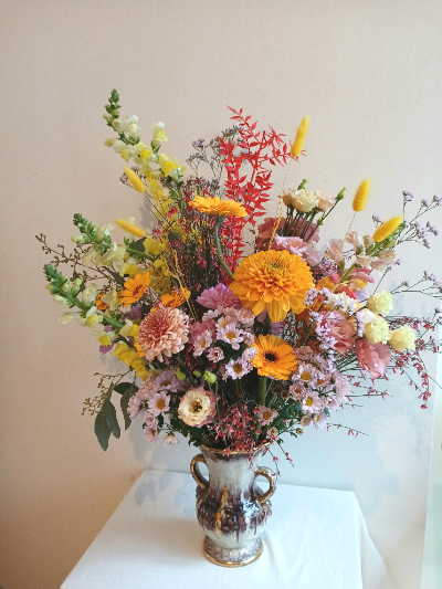 gros bouquet avec différentes fleurs composées des couleurs orange, vert, rouge et rose