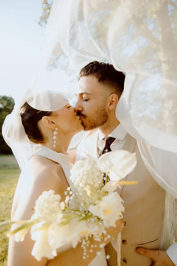 un couple de mariés lors d’un mariage s’embrasse
