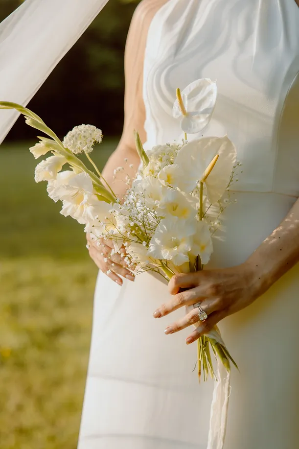 lors d’un mariage, photo de la mariée tenant un petit bouquet de fleurs blanches
